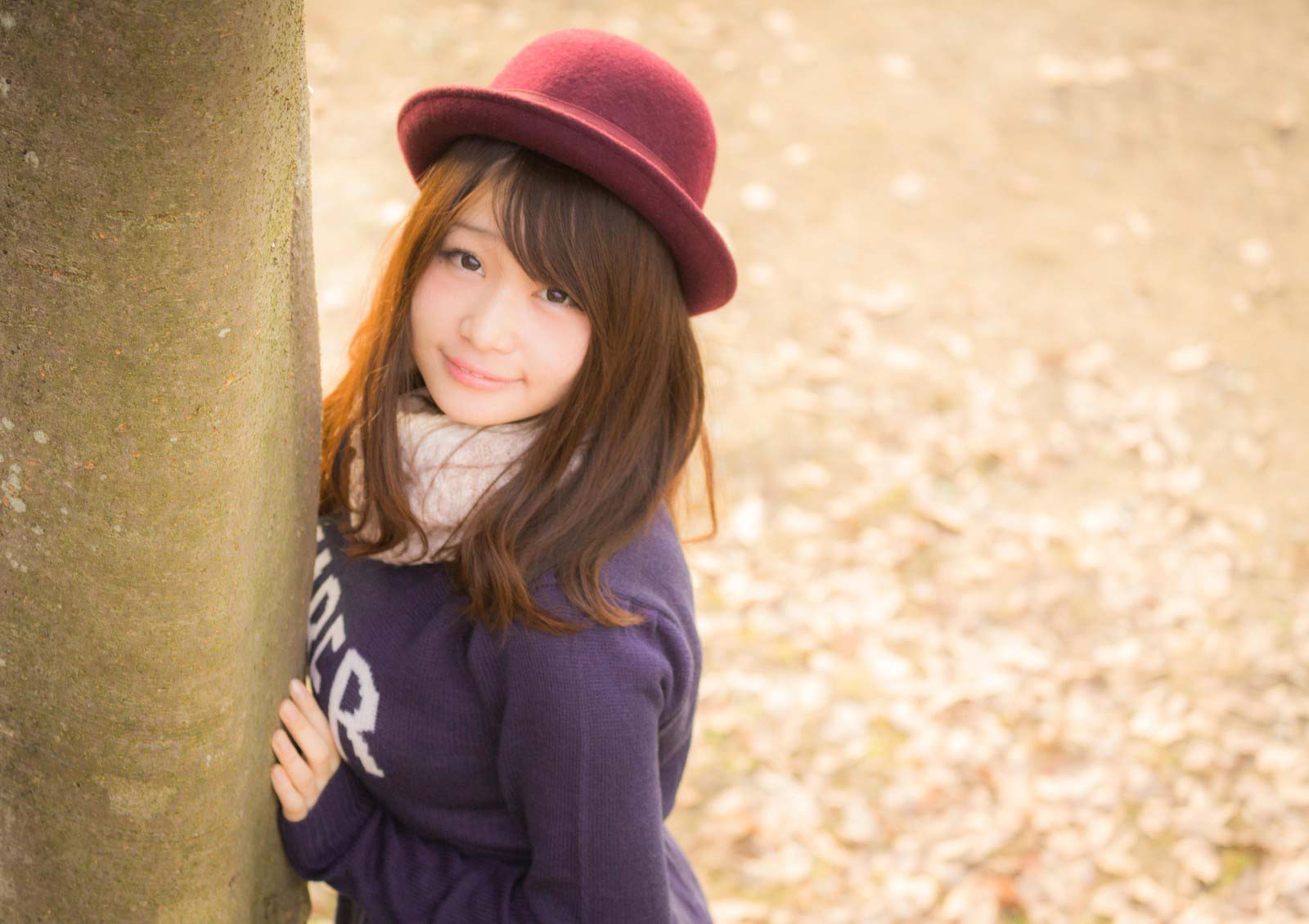 木陰から覗いている帽子を被った女性