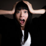 頭を抱えて叫んでいる女性