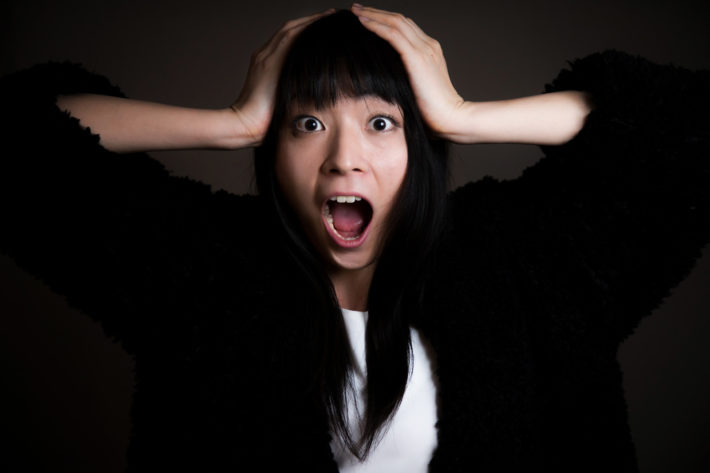 頭を抱えて叫んでいる女性