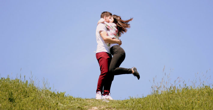 男性の胸に飛び込んでキスをしている女性