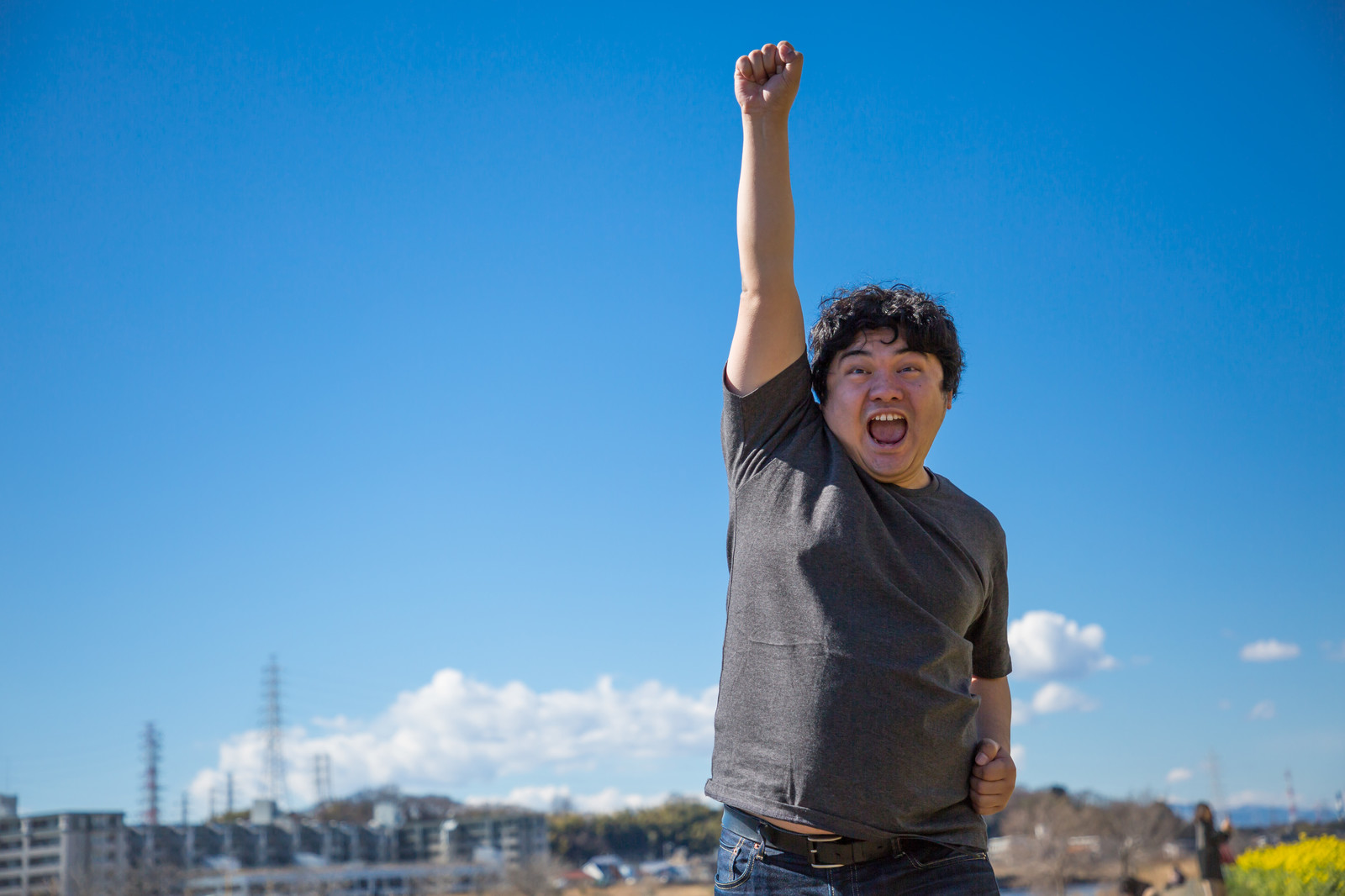 空に拳を掲げシャウトしている太った男性