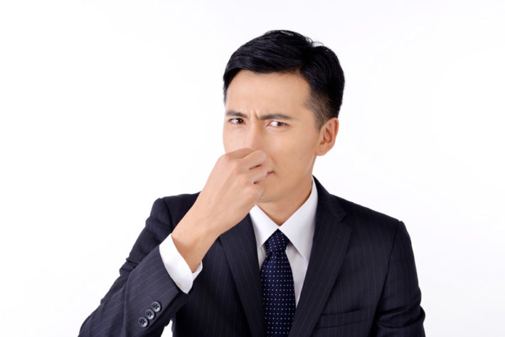 鼻をつまんでいるサラリーマン男性