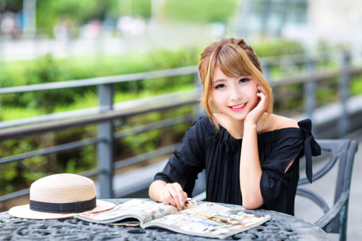 頬杖をついて雑誌をみている女性