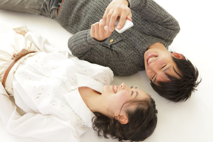寝転んで笑い合う男女