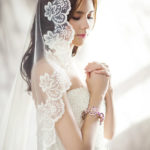 ウェディングドレスを着て祈っている女性