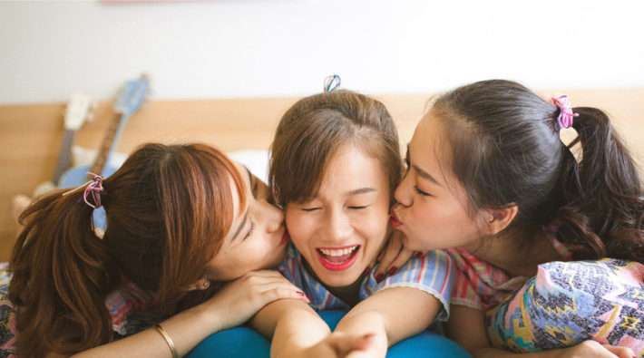 両頬に左右からキスをされている女性