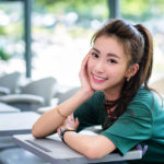 教室の机で頬杖をついている女性