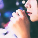 寂しげな女性の横顔と夜の街のネオン