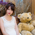 テディベアと一緒にソファーに座っている女性