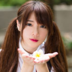 掌に花びらを乗せてコチラを見ている可愛いオタク女性