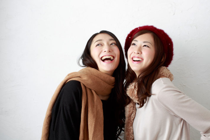 笑いながら天井を見上げている女性2人組