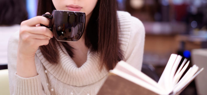 珈琲を飲みながら本を読んでいる女性