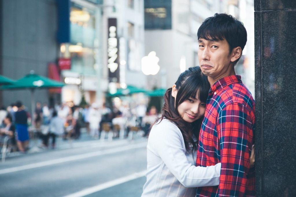 可愛い子から抱きしめられているのにしかめっ面の男性
