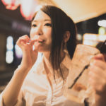 飲み会で枝豆を食べているブスな女性