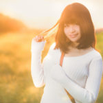 夕日に背を向け微笑む女性