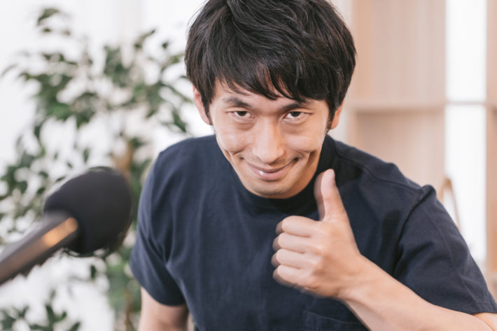 親指を立ててニヤリと笑っている男性
