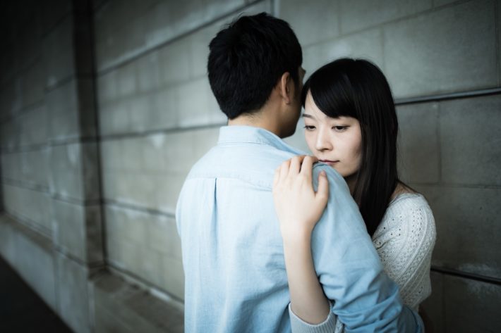 悲しそうな顔で抱きしめられている女性