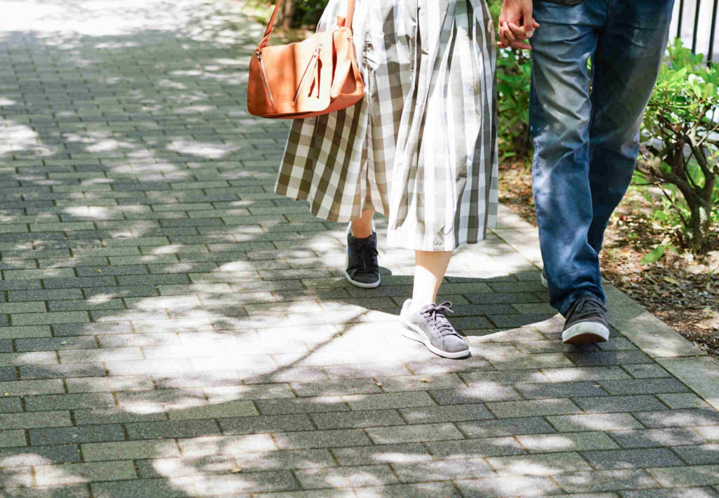 手をつないで街を歩いている男女