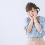 頬に手を当てて不安そうにしている女性