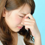 目尻を押さえる女性