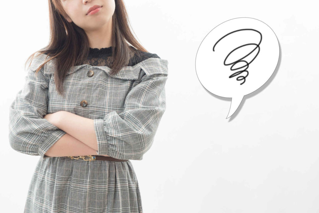 腕を組んで悩んでいる女性