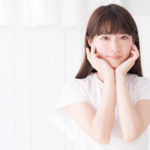 顎に手を当ててこちらを見つめている女性