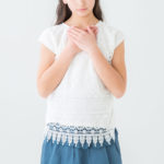 緊張して胸に手を当てている女性