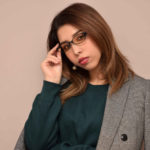 メガネの縁を持ってかけ直している女性