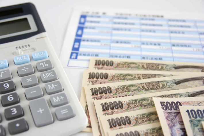 年収計算で机に置かれた電卓と源泉徴収
