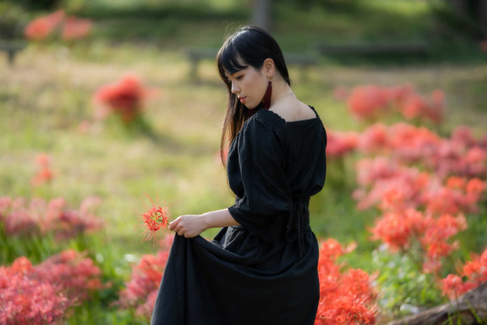 花畑でポーズを取っている女性の後ろ姿