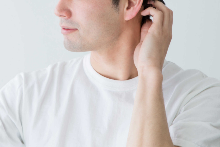 鏡を見て髪を気にしている男性