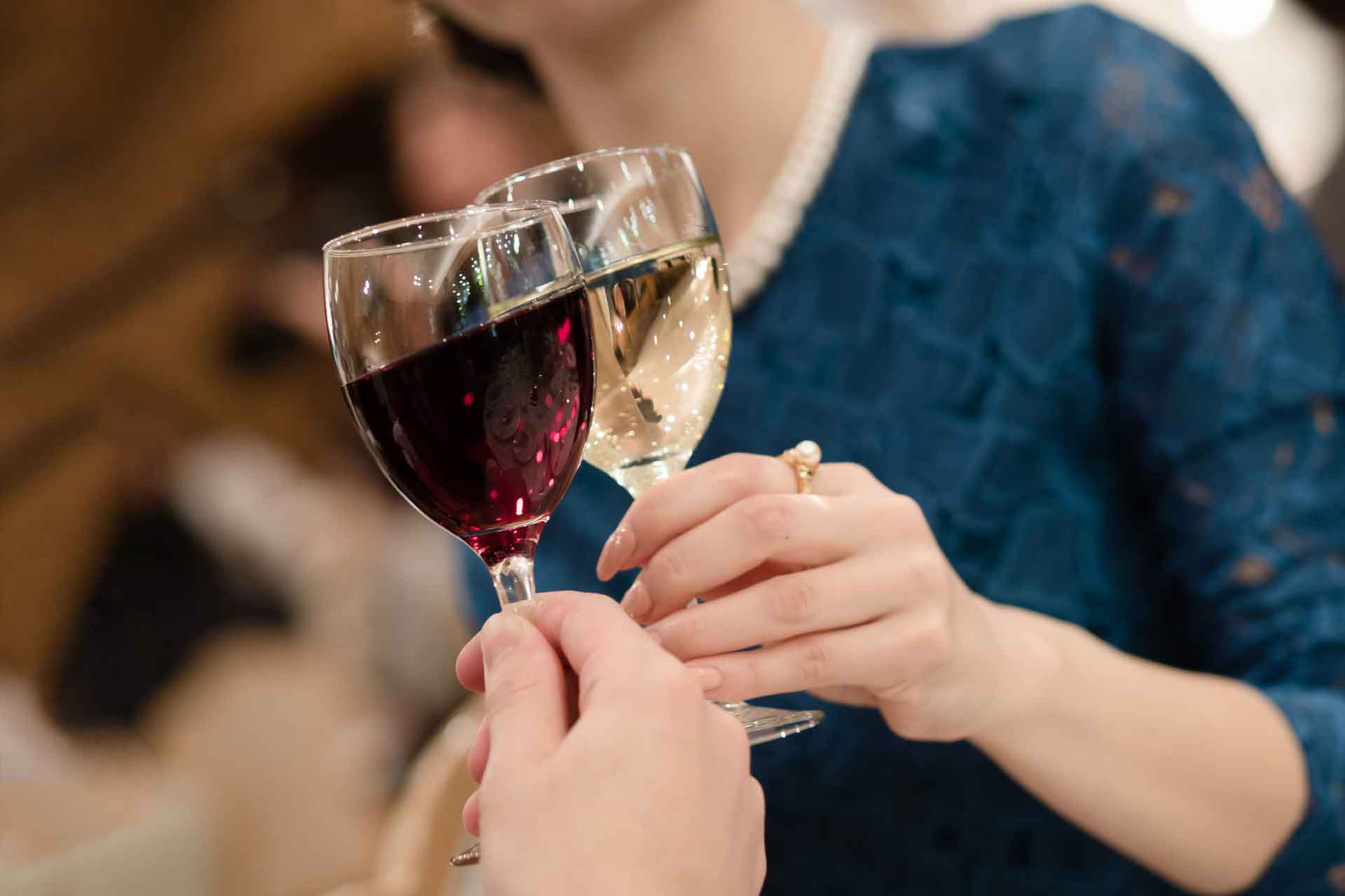 ワイングラスで乾杯する、ドレすあっぷした女性の胸元