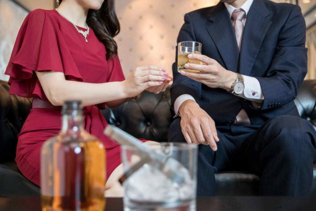 ラウンジのソファーに座りお酒を飲んでいる男女